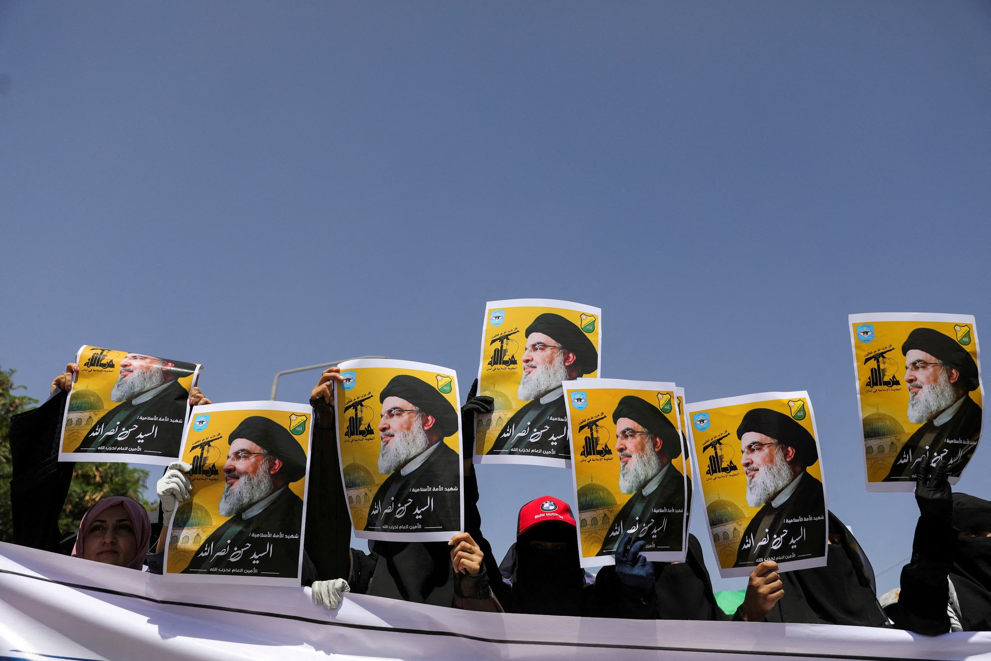 Students hold posters of Hassan Nasrallah, the assassinated chief of Lebanon's Hezbollah, during a rally in Sanaa