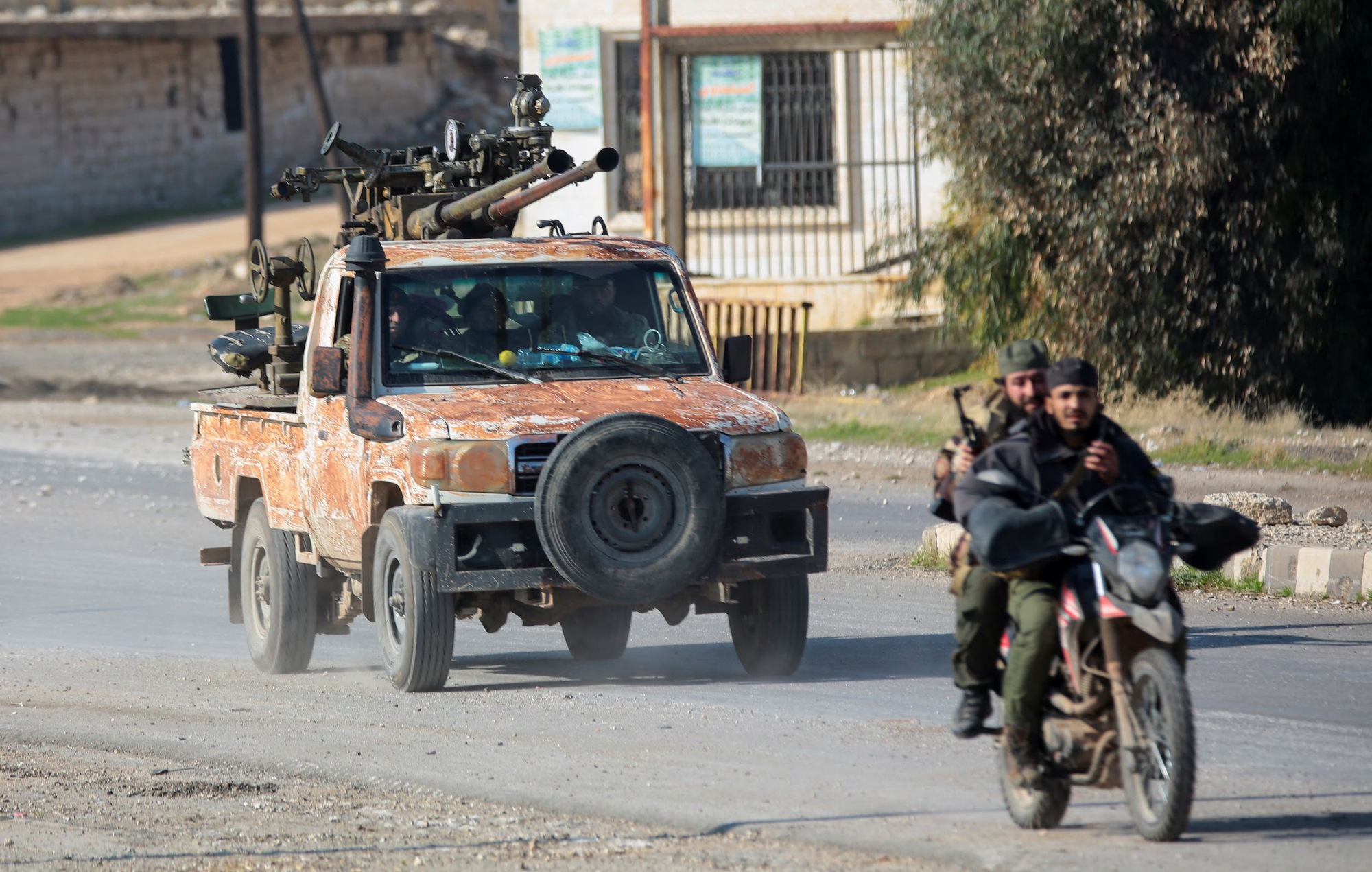 Rebels led by the Islamist militant group Hayat Tahrir al-Sham drive on a motorbike in al-Rashideen