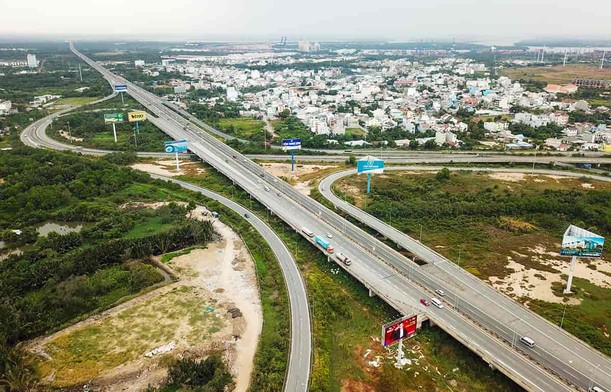 Thị trường bất động sản vệ tinh Tp.HCM sôi động cuối năm- Ảnh 2. A road with cars on it Description automatically generated