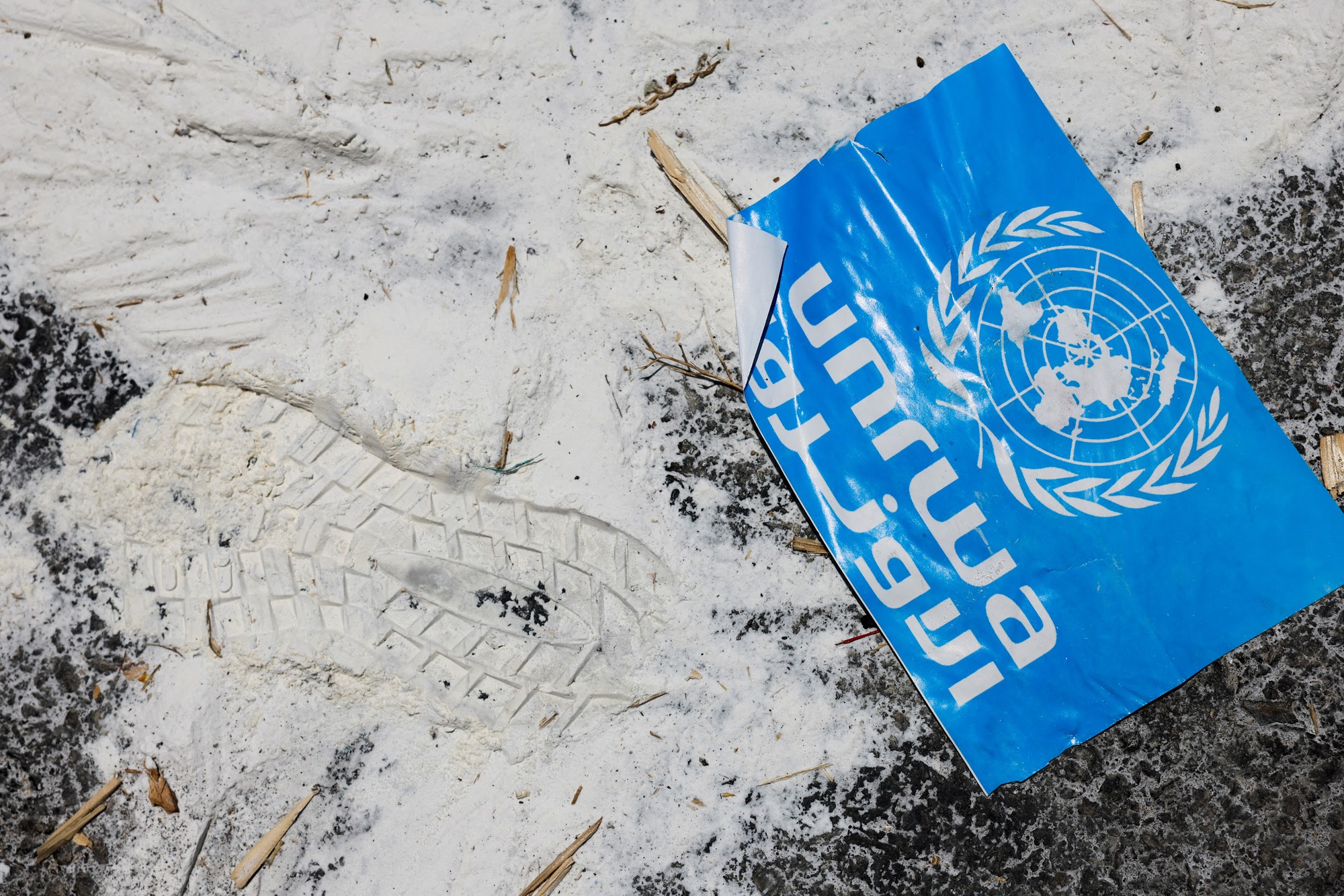 A United Nations Relief and Works Agency (UNRWA) sign lies on the ground, amid the ongoing conflict in Gaza between Israel and the Palestinian Islamist group Hamas,  at the Kerem Shalom crossing in southern Israel