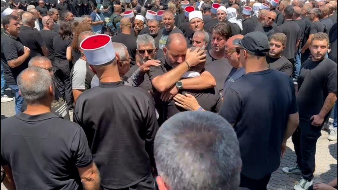 Members of the Druze community in Majdal Shams console each other after the loss of their young.