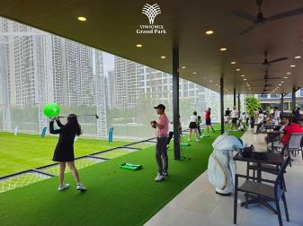 People playing golf in a building  Description automatically generated