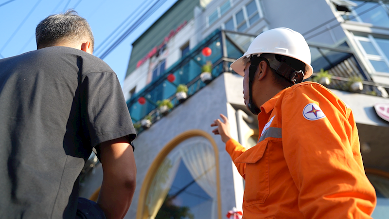 A person in a helmet and orange jumpsuit  Description automatically generated