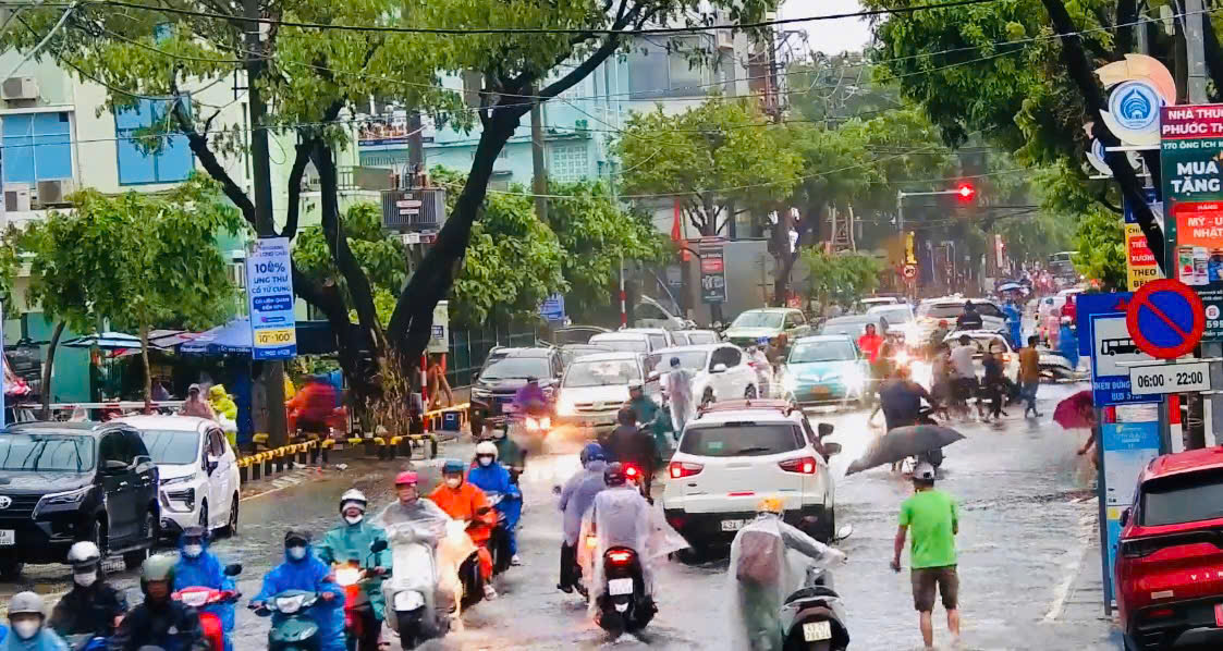 Tuyến đường Quang Trung đã bị ngập, một số người dân đi xe máy phải dắt bộ.