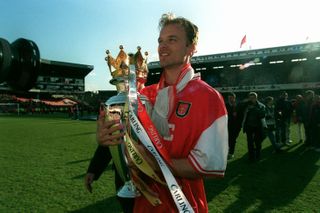 Dennis Bergkamp ăn mừng với chiếc cúp Premier League sau khi giành chức vô địch 1997/98 cùng Arsenal