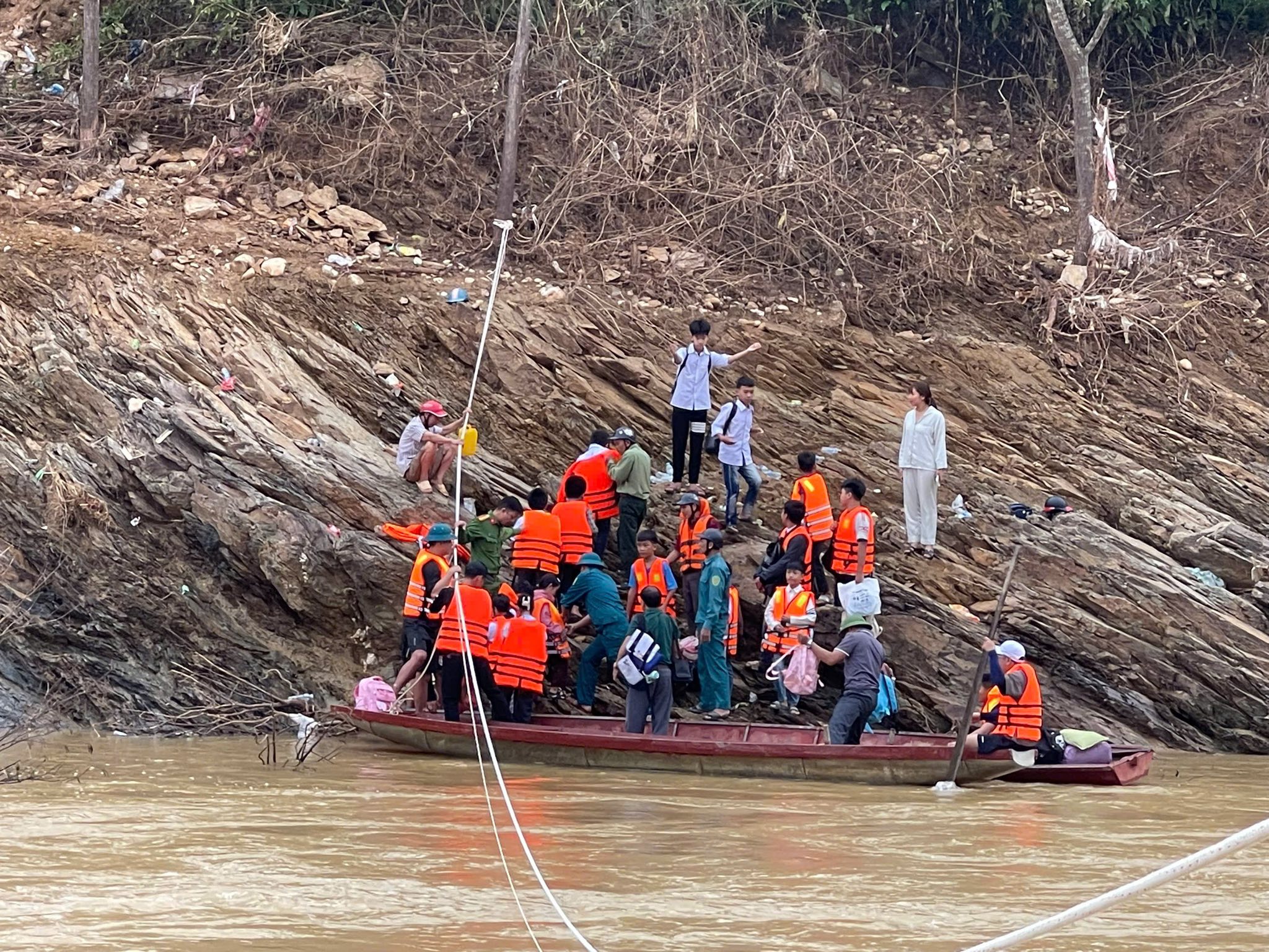 Cầu cứng bị cuốn trôi, dùng thuyền vượt sông đưa hàng trăm học sinh đến trường - Ảnh 5.