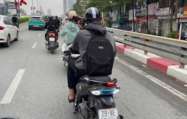 Một thanh niên bị xử phạt 900.000 đồng vì vừa lái xe vừa lướt điện thoại - Ảnh 1.