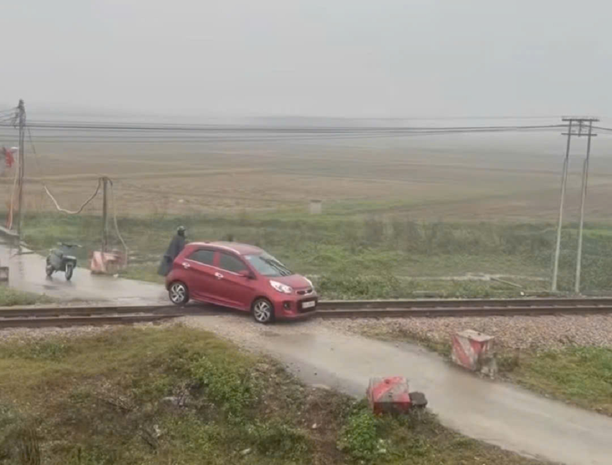 Thót tim cảnh ô tô mắc kẹt trên đường ray khi đoàn tàu hỏa đang lao tới - Ảnh 1.