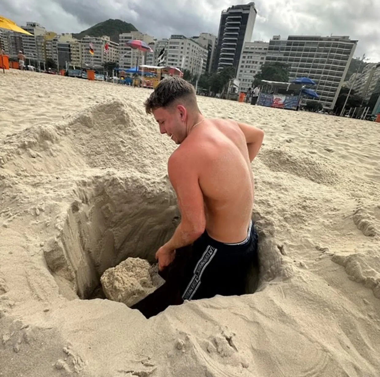 Jensen Sturgeon đào hố cát trên bãi biển Copacabana. Jensen Sturgeon đào hố cát trên bãi biển Copacabana.