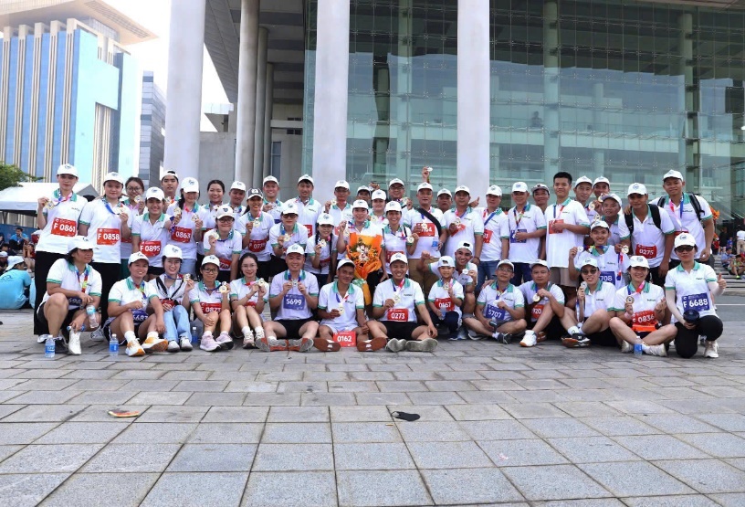 Nutifood ủng hộ 500 triệu “Chung tay xóa nhà tạm, nhà dột nát” tỉnh Bình Dương- Ảnh 2. A group of people posing for a photo AI-generated content may be incorrect.