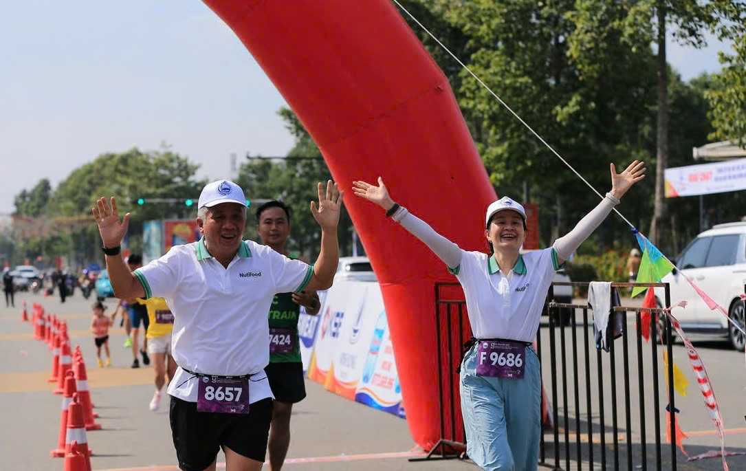 Nutifood ủng hộ 500 triệu “Chung tay xóa nhà tạm, nhà dột nát” tỉnh Bình Dương- Ảnh 3. A group of people running in a marathon AI-generated content may be incorrect.