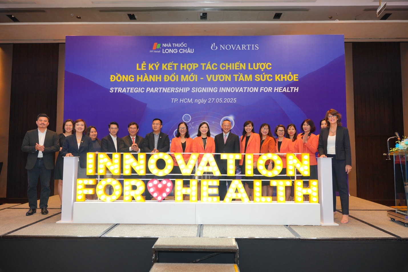 Hợp tác mang các giải pháp điều trị mới cho người bệnh mãn tính tại Việt Nam như các nước hàng đầu thế giới- Ảnh 1. A group of people standing on a stage AI-generated content may be incorrect.