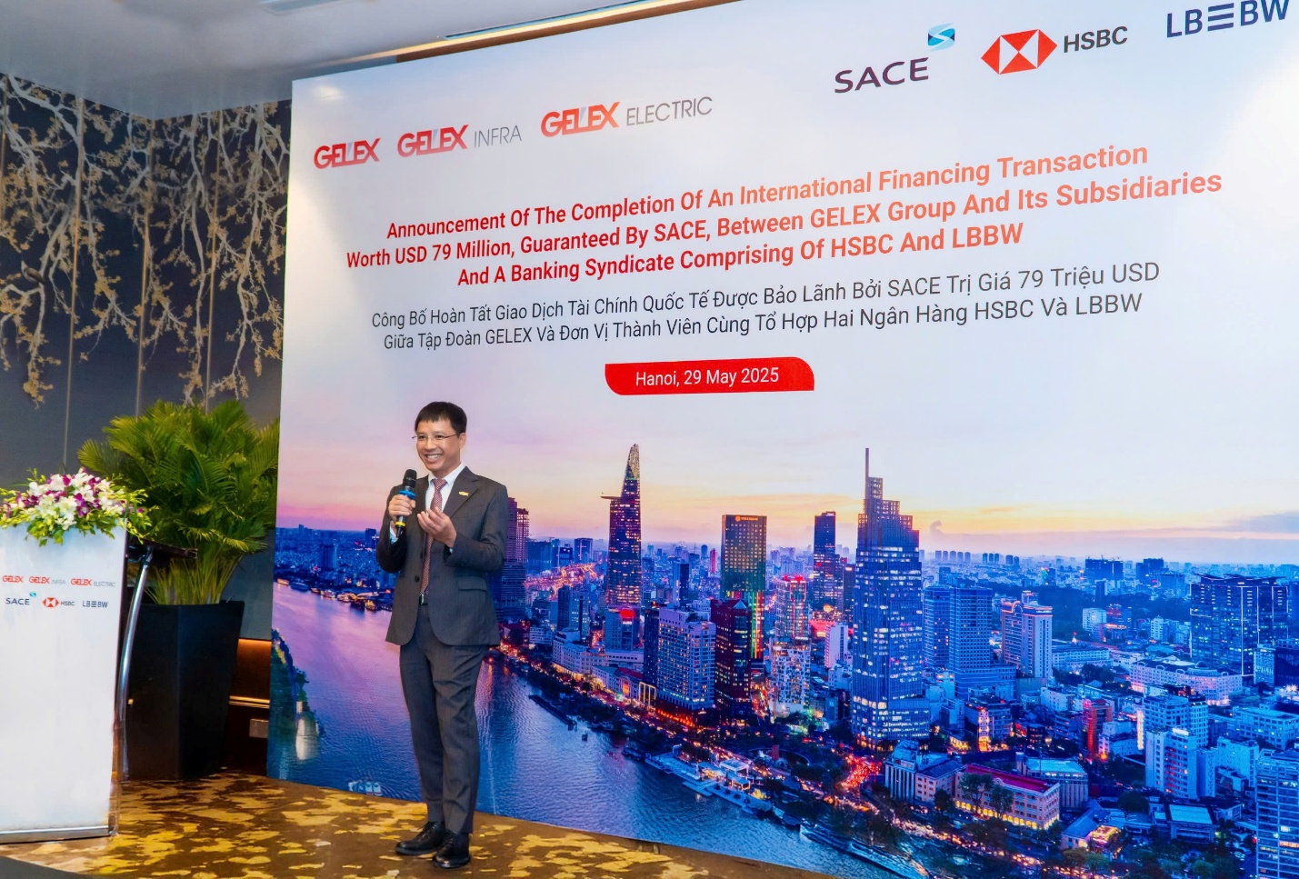 GELEX công bố hoàn tất giao dịch bảo lãnh khoản vay không ràng buộc trị giá 79 triệu USD- Ảnh 2. A person standing in front of a large poster AI-generated content may be incorrect.