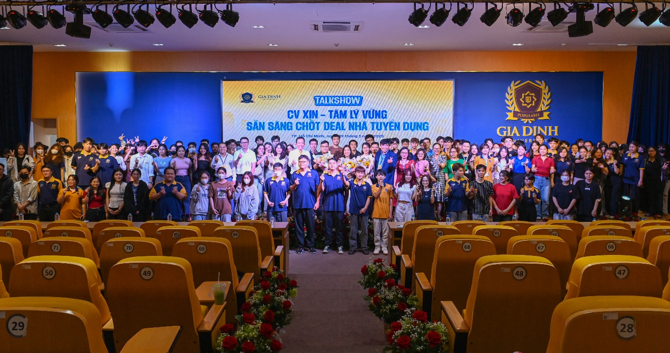 Trường Đại học Gia Định kiến tạo “hệ sinh thái” kết nối sinh viên và doanh nghiệp- Ảnh 3. A group of people standing in a room with chairs AI-generated content may be incorrect.