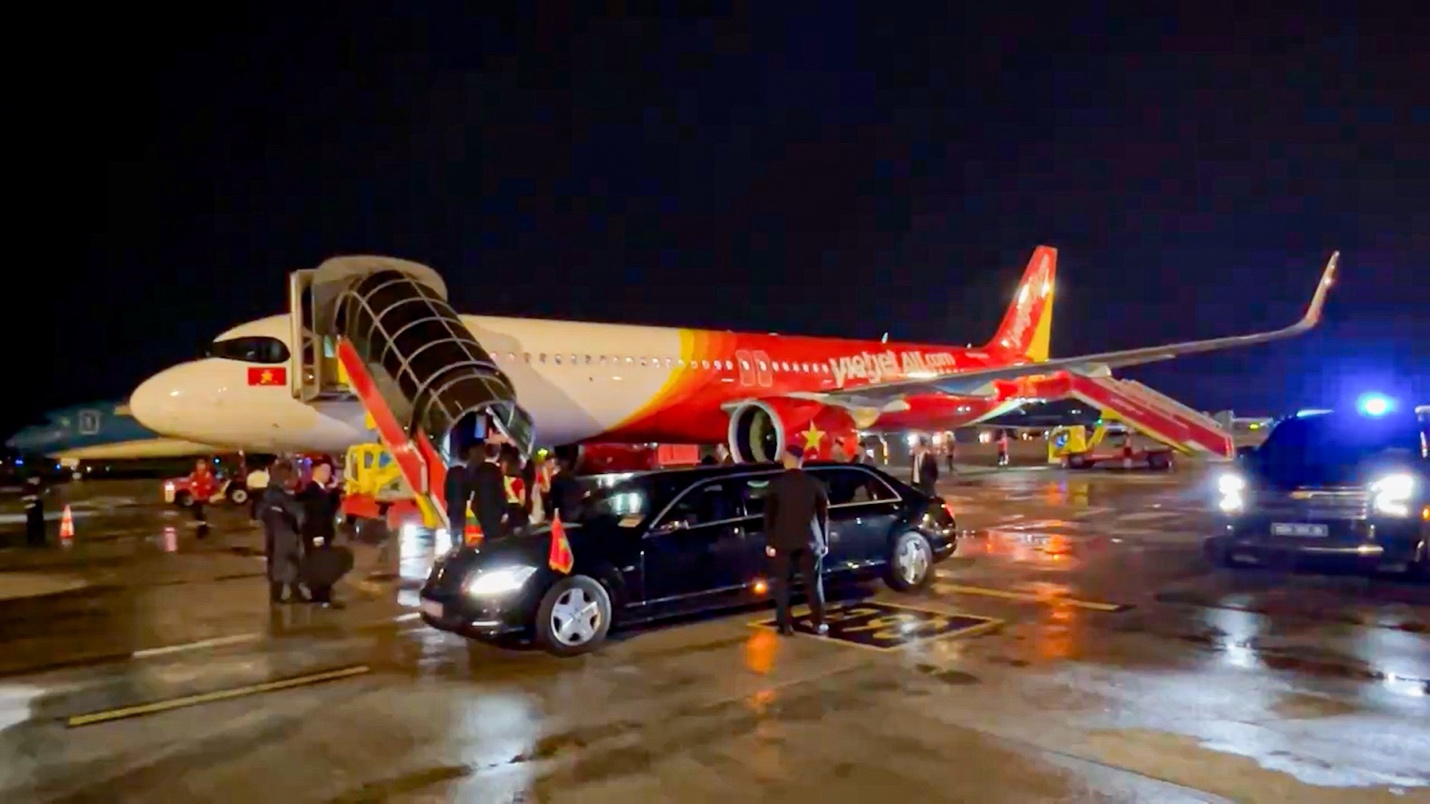 Tổng thống Litva đến Hà Nội trên chuyên cơ Vietjet- Ảnh 5. A car parked next to a plane Description automatically generated