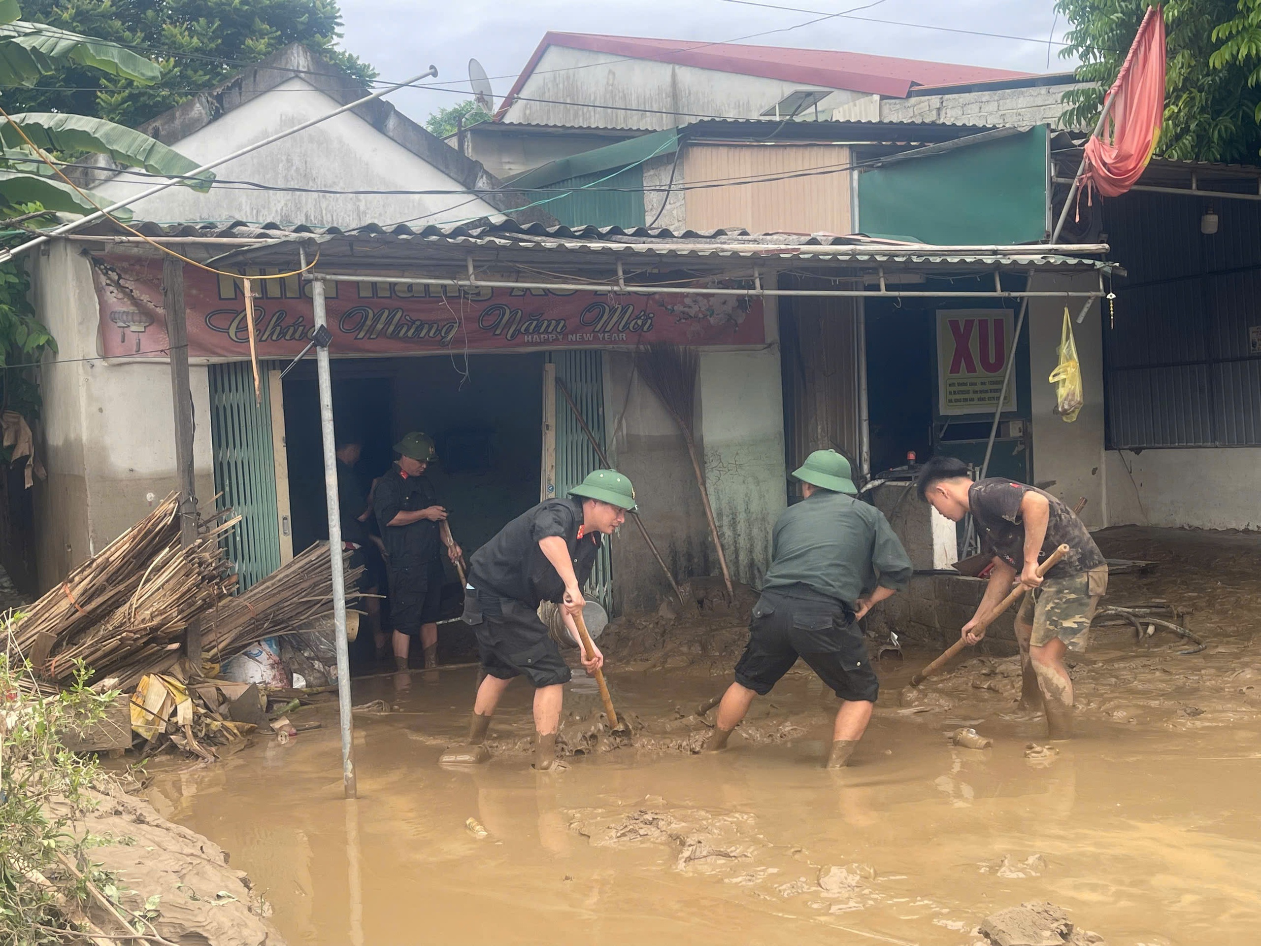 Cảnh sát cơ động giúp dân dọn bùn đất sau mưa lũ- Ảnh 9.