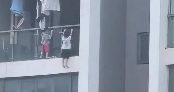 Trẻ trèo ra ngoài ban công chung cư "hít xà", hàng xóm sợ hãi la hét - Ảnh 1.