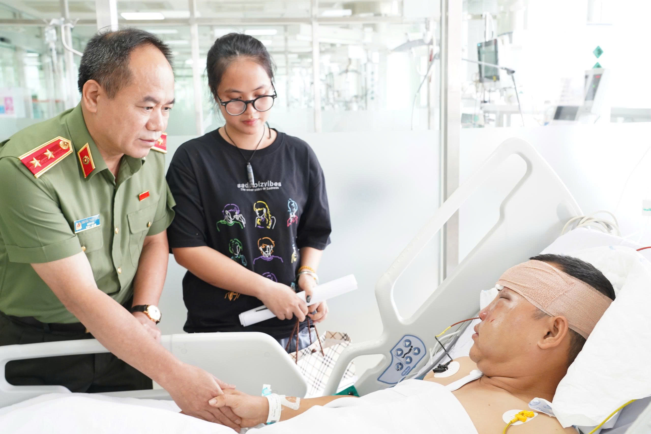 Giám đốc CATP Hà Nội thăm hỏi, động viên cán bộ bị thương khi làm nhiệm vụ - Ảnh 1.