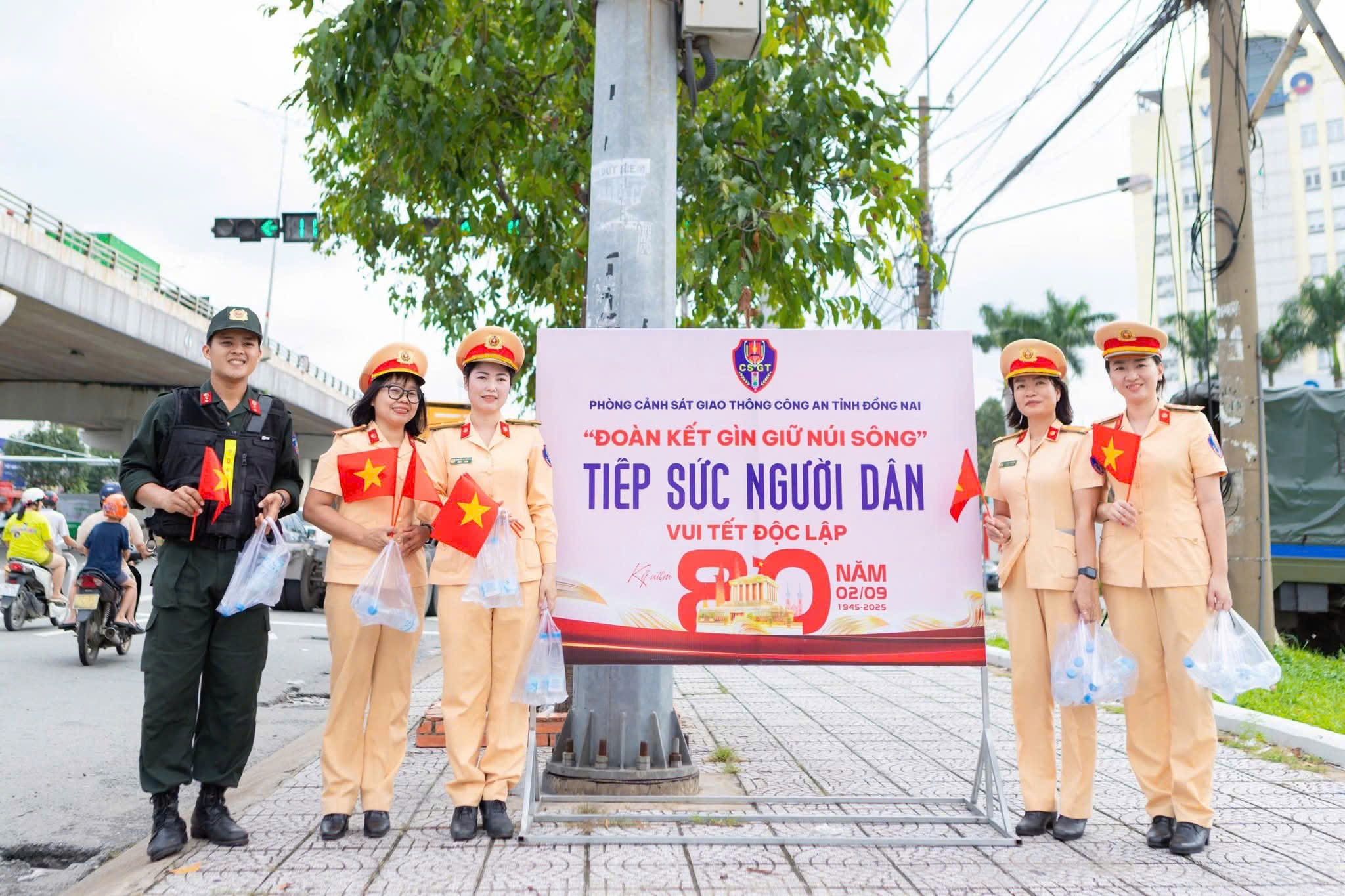 Ấm áp hình ảnh nữ CSGT xinh đẹp phát nước tặng người dân ở Đồng Nai - Ảnh 1.
