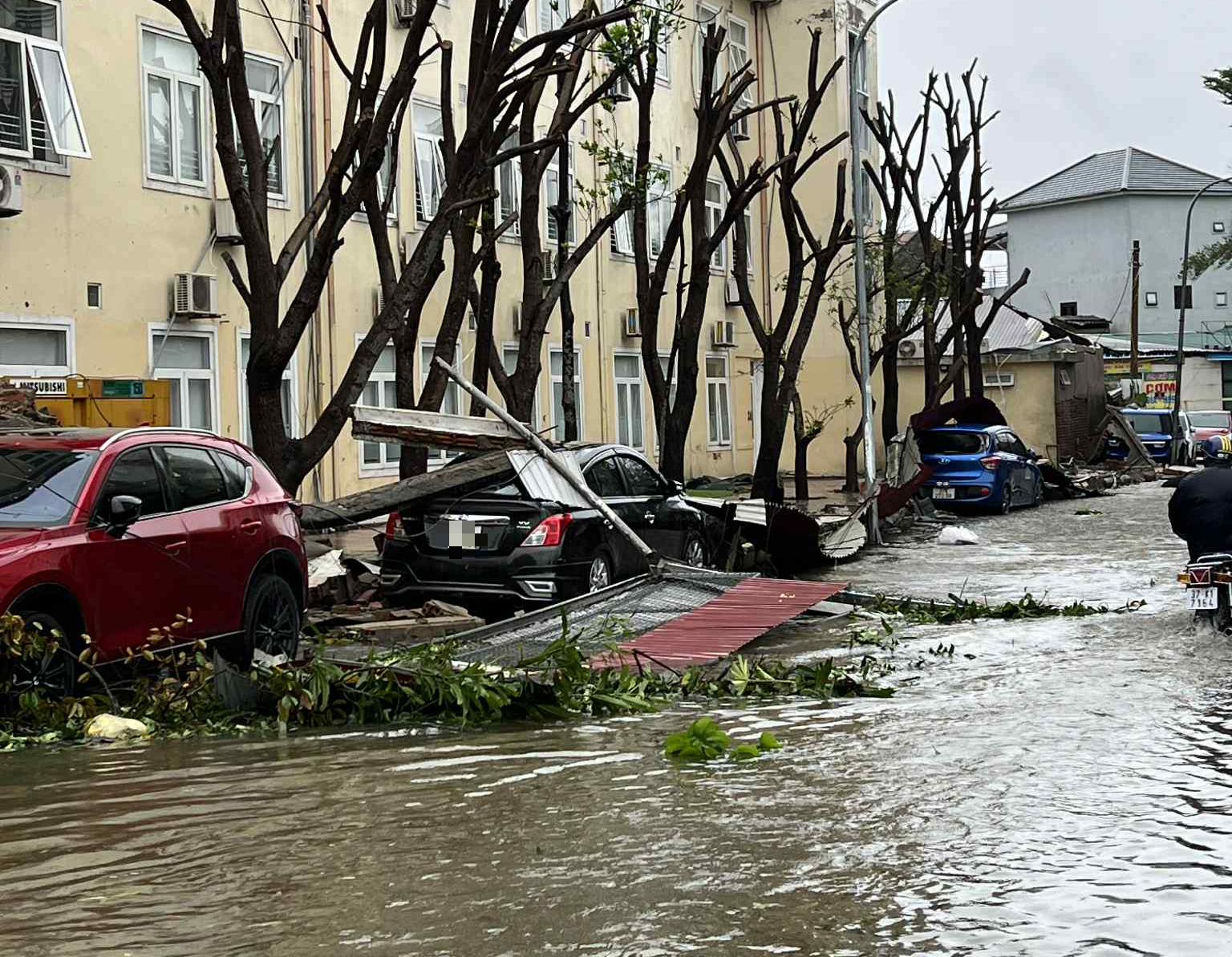 Hàng loạt ô tô bị hư hỏng sau bão Bualoi, xe máy bị quật ngã ngổn ngang- Ảnh 2.