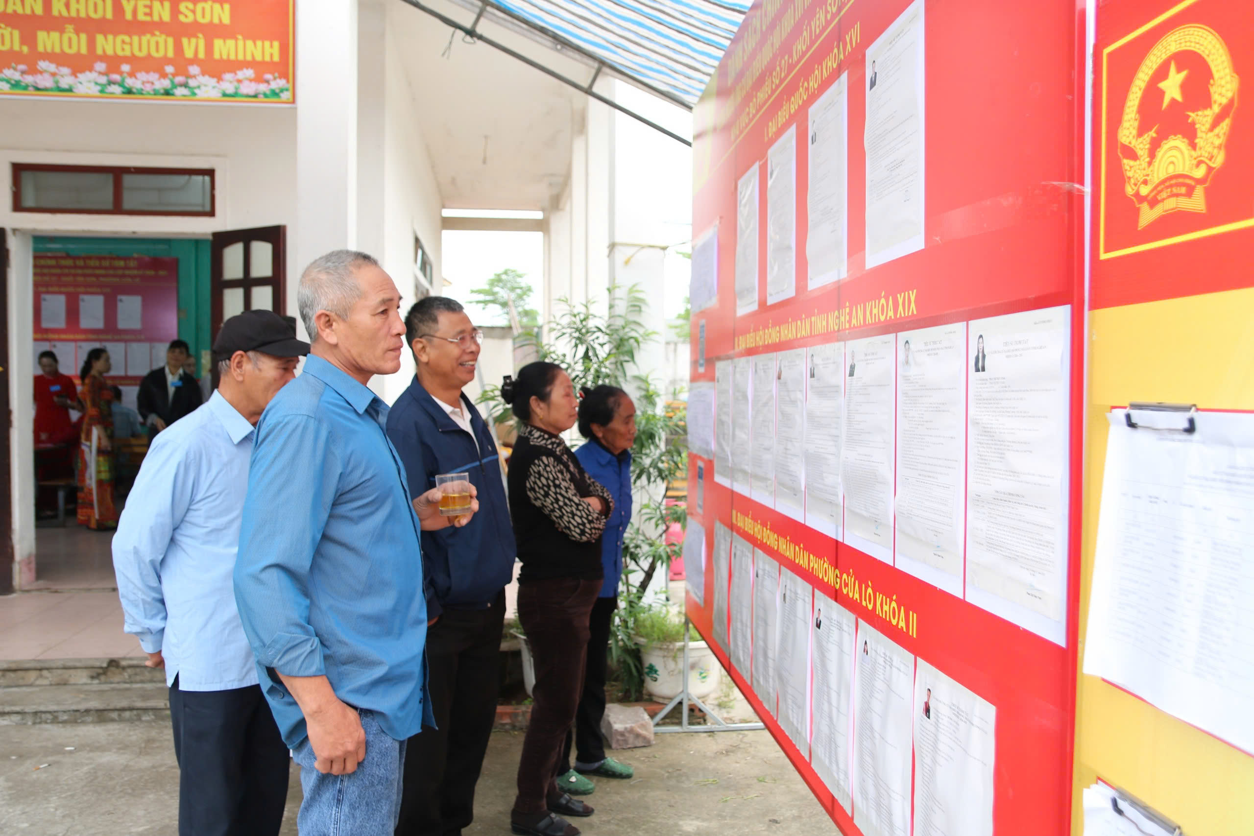 Cử tri lớn tuổi được kiểm tra sức khỏe và hỗ trợ đọc lý lịch ứng cử viên khi đi bầu cử- Ảnh 7.