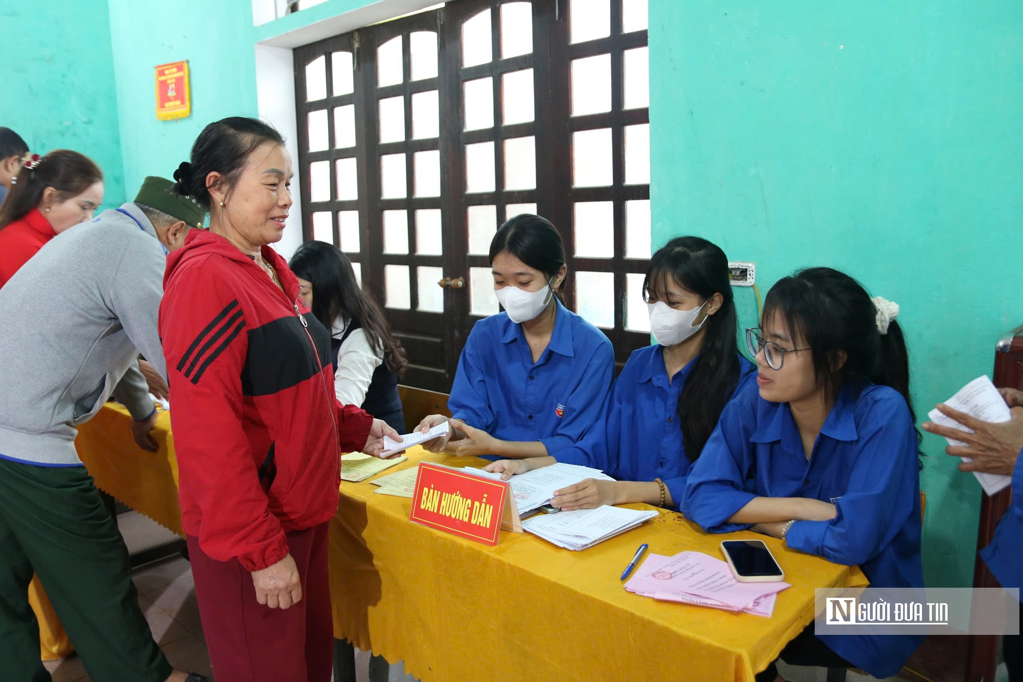 Cử tri lớn tuổi được kiểm tra sức khỏe và hỗ trợ đọc lý lịch ứng cử viên khi đi bầu cử- Ảnh 8.