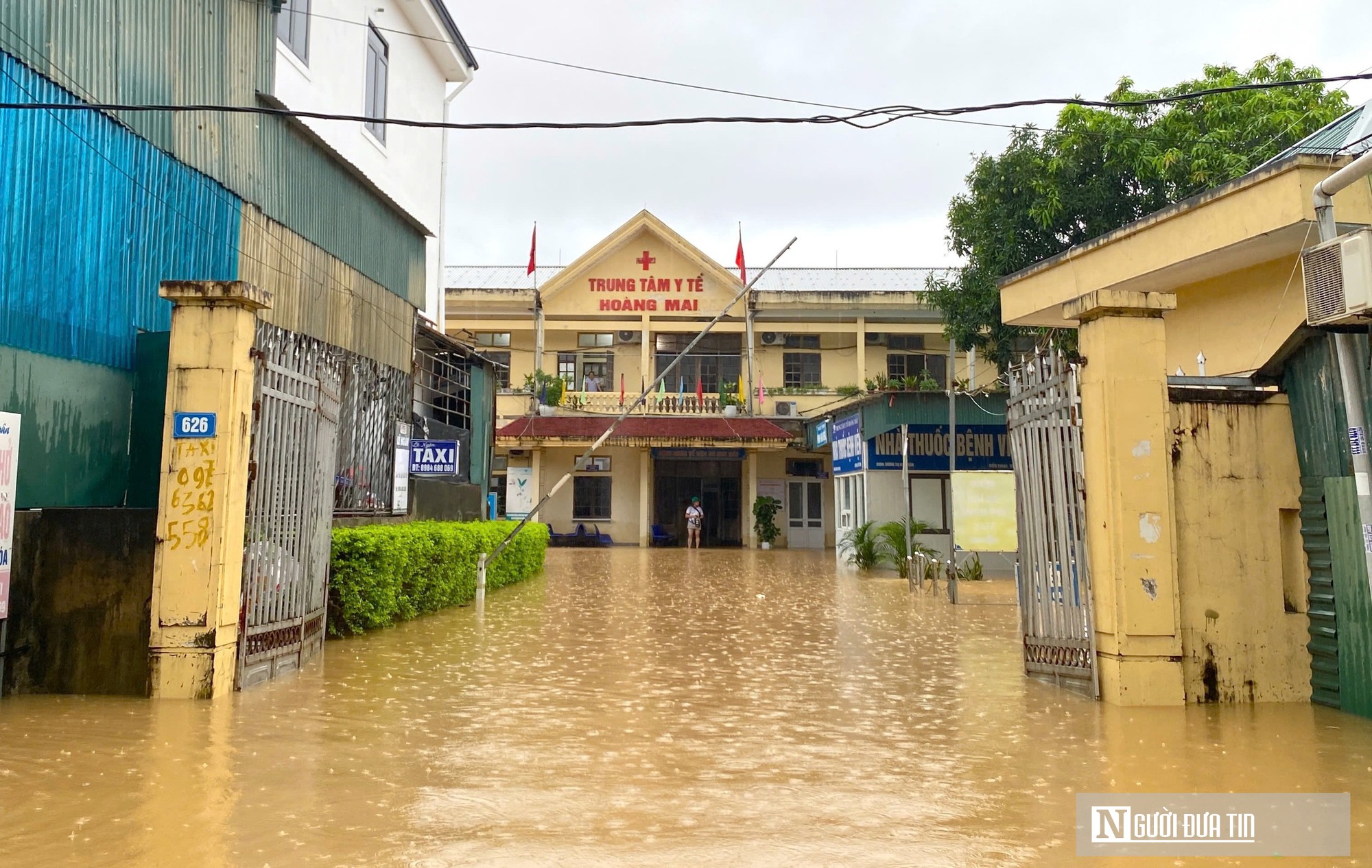 Nước lũ bủa vây Trung tâm Y tế Hoàng Mai, công an dùng thuyền đưa đón bệnh nhân thăm khám- Ảnh 1.