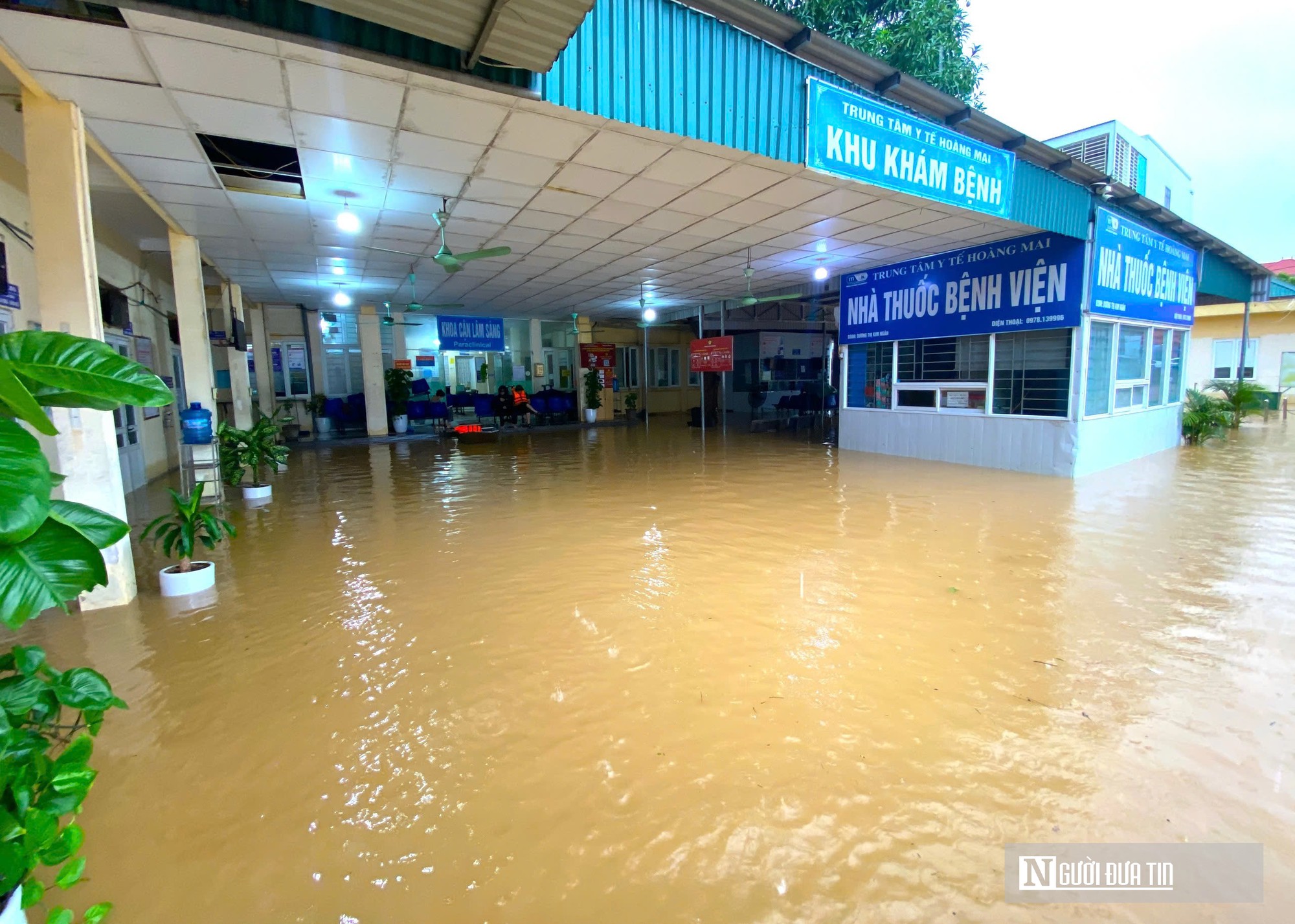 Nước lũ bủa vây Trung tâm Y tế Hoàng Mai, công an dùng thuyền đưa đón bệnh nhân thăm khám- Ảnh 2.