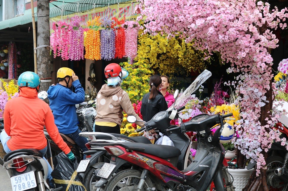 Các loại hoa mai, hoa đào, tầm xuân,... trang trí có giá 120.000 đồng/kg. Các loại bánh chưng, thỏi vàng giả kích thước lớn có giá từ 400.000 - 450.000 đồng/sản phẩm.