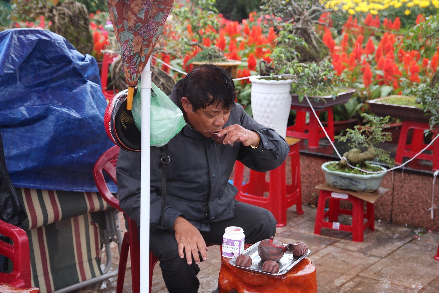 Cơn mưa dầm dề đã khiến nhiều mặt hàng khác tại chợ hoa ế ẩm. Những tách trà nóng giúp họ xua đi cơn lạnh giá cuối năm.