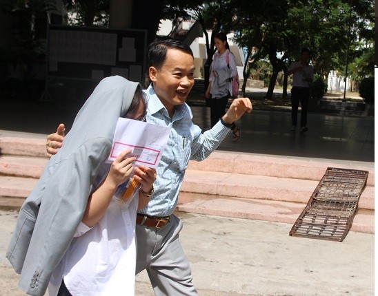Ông bố trẻ rạng rỡ đón con. Chiếc áo vest được người bố này cởi ra che nắng cho con gái. Nghe con kể đã làm tốt bài thi, người bố vui mừng, hớn hở.