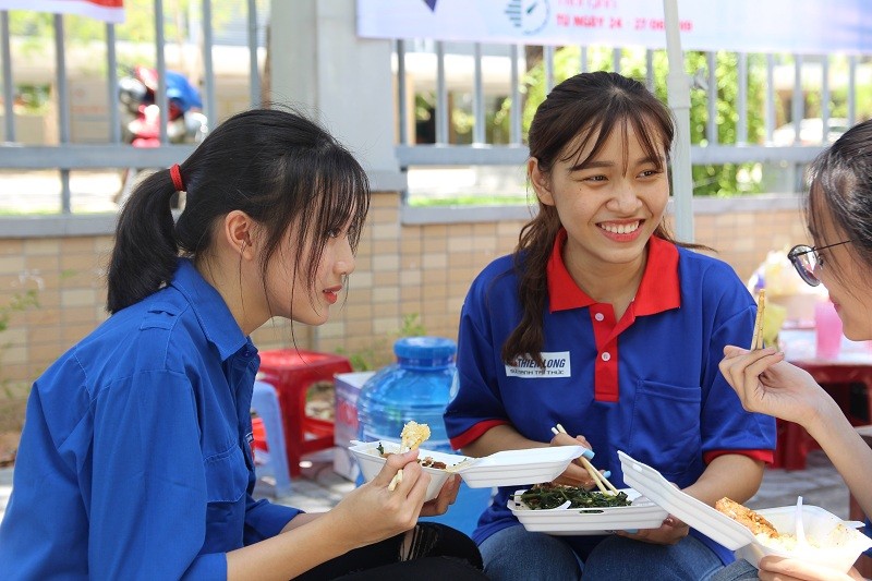 Bữa cơm bụi ngay tại sân trường điểm thi. Nụ cười tươi vẫn nở trên môi những cô gái trẻ.