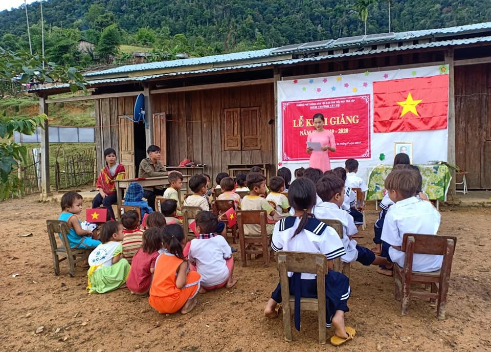 Cô Trà Thị Thu đọc thư chúc mừng khai giảng của Tổng Bí thư, Chủ tịch nước cho các trò nghe. Điểm trường này, có 2 cô giáo áo dài chỉn chu. Trên bục có ảnh Bác Hồ, cờ Tổ quốc đỏ rực. Ngoài bàn tay khéo léo của 2 cô giáo nhỏ tuổi đôi mươi, người làng Pắk Pó cũng đến phụ giúp.
