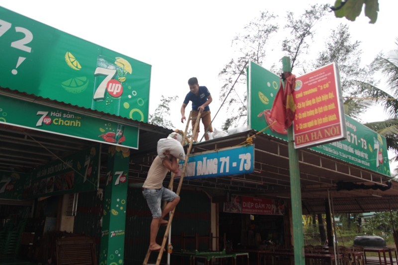 Hàng trăm bao cát được đem lên mái nhà để gia cố các cửa hàng.