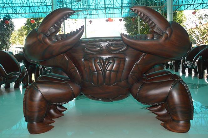 Hai đầu bàn là hai chú cua khổng lồ giơ càng được làm bằng gỗ lim, hỗ trợ thêm cho hai chú cua này là hai chiếc ghế nhỏ đặt ở giữa bàn phía dưới.