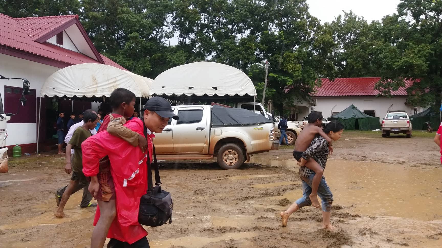 Nhóm PV đang cõng các nạn nhân về điểm di trú, để đội ngũ y, bác sĩ tiến hành khám, sơ cứu cho họ.