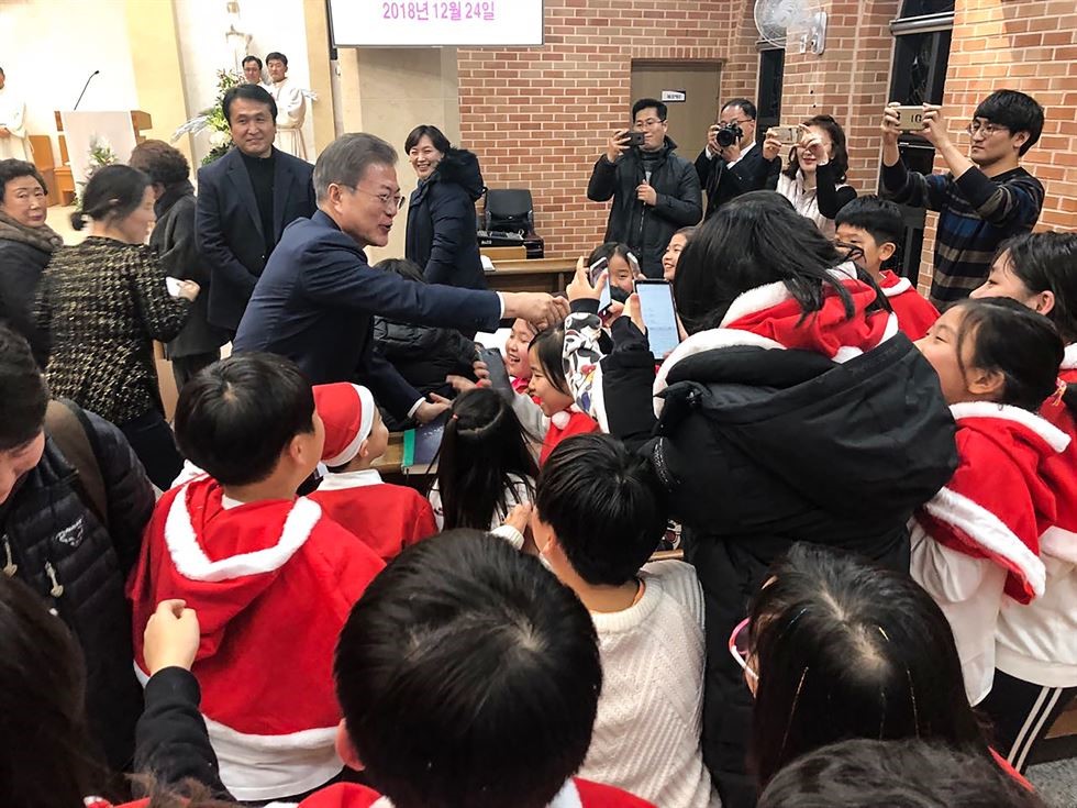 Tổng thống Hàn Quốc Moon Jae-In bắt tay với trẻ em tại một nhà thờ Công giáo ở Yangsan, tỉnh Nam Gyeongsang, vào đêm Giáng sinh. Ảnh Yonhap.