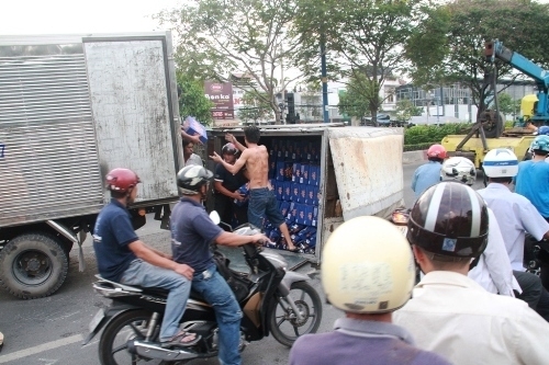 Ph&aacute;p luật - Xe tải chở bia lật, người đi đường một phen h&uacute; v&iacute;a (H&igrave;nh 2).