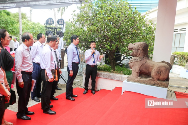 Thuyết minh viên của Bảo tàng tỉnh giới thiệu về cặp tượng sư tử đá thành Đồ Bàn. Ảnh: Thu Dịu