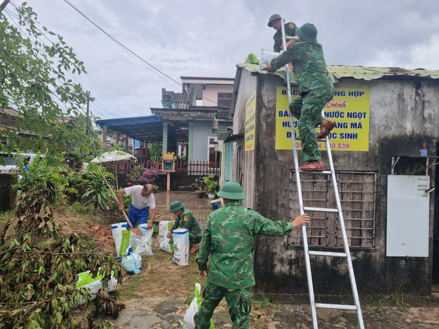 Bộ đội Biên phòng gia cố nhà cửa giúp dân trước khi áp thấp nhiệt đới mạnh lên thành bão- Ảnh 1.