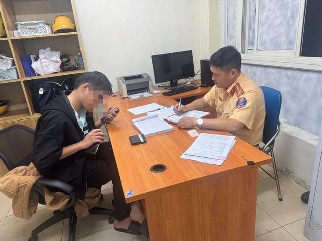 Một thanh niên bị xử phạt 900.000 đồng vì vừa lái xe vừa lướt điện thoại - Ảnh 2.