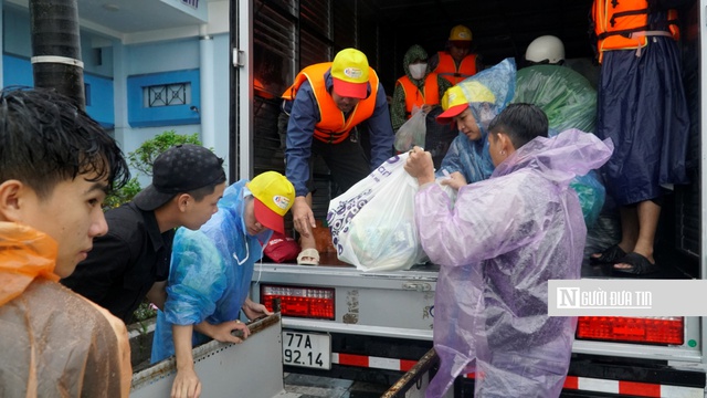 Luộc trứng, gói cơm, chia quần áo cho bà con vùng lũ- Ảnh 1.