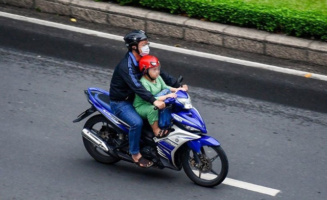 Cho trẻ em ngồi phía trước xe máy có thể bị phạt 10 triệu đồng - Ảnh 1.
