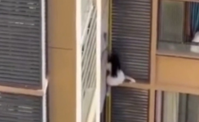 Người phụ nữ trèo ra khỏi cửa sổ căn hộ khiến hàng xóm sốc nặng - Ảnh 1.