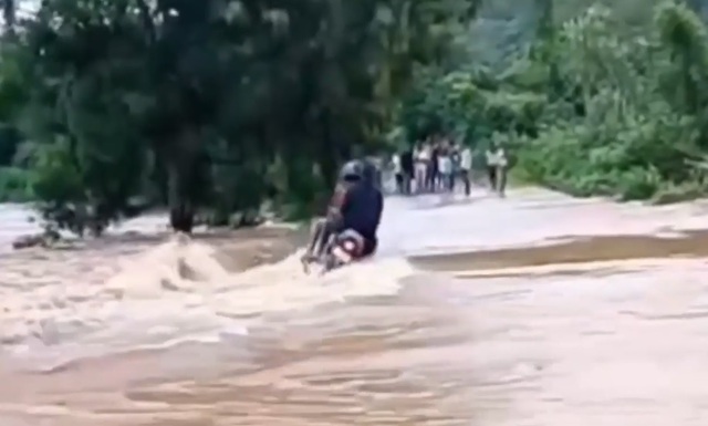 Cố băng qua cầu ngập nước, 3 người đi xe máy bị nước cuốn trôi - Ảnh 1.