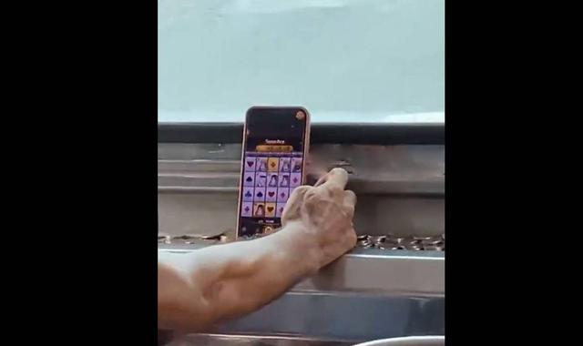 Tài xế vừa lái xe vừa chơi game đánh bạc trực tuyến - Ảnh 1.