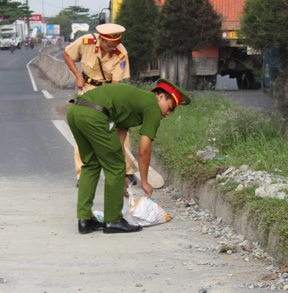 CSGT quét dọn đá dăm trên đường giúp dân