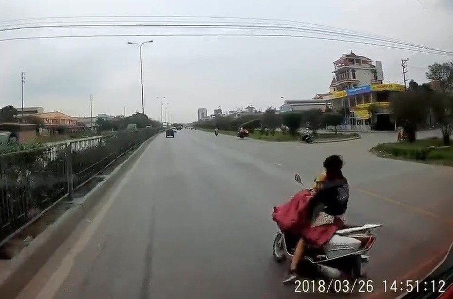 Clip: Cởi áo mưa khi đang lái xe, nữ tài xế suýt chết trước đầu ô tô