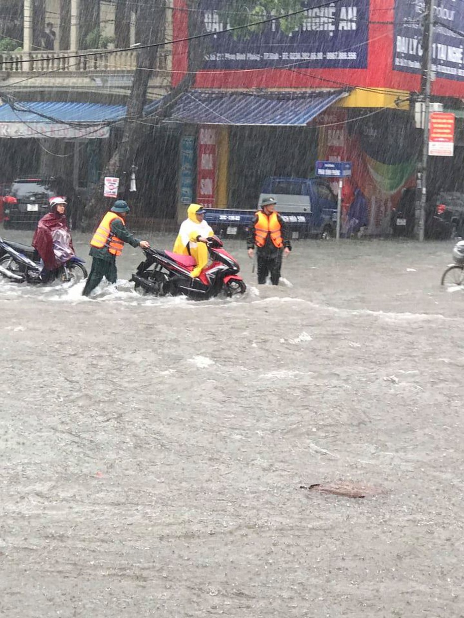 Xúc động hình ảnh cảnh sát dầm mưa giúp người dân lưu thông nơi ngập lụt