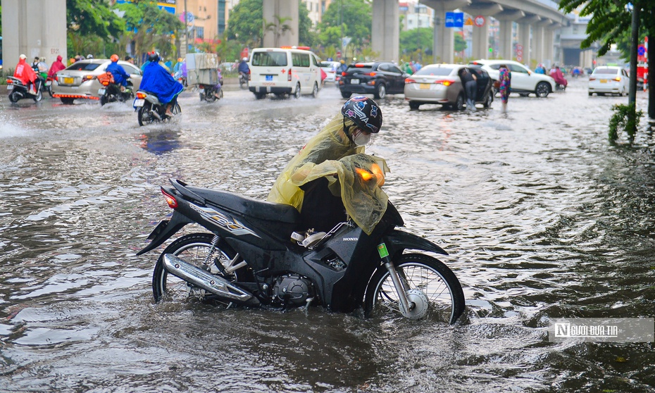 Cơn mưa lớn bất chợt giữa trưa khiến đường phố Hà Nội ngập sâu